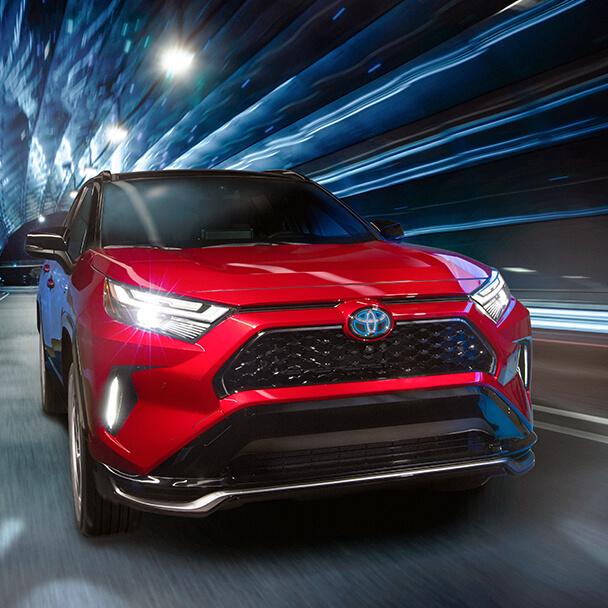 red Toyota RAV4 Prime driving through a tunnel at night