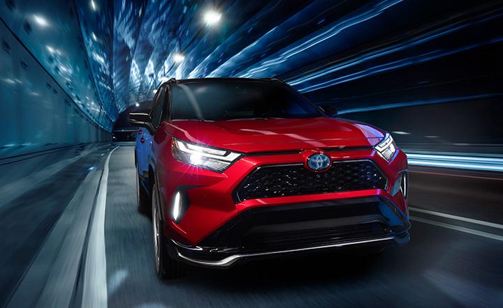 red Toyota RAV4 Prime electric hybrid driving through a tunnel at night