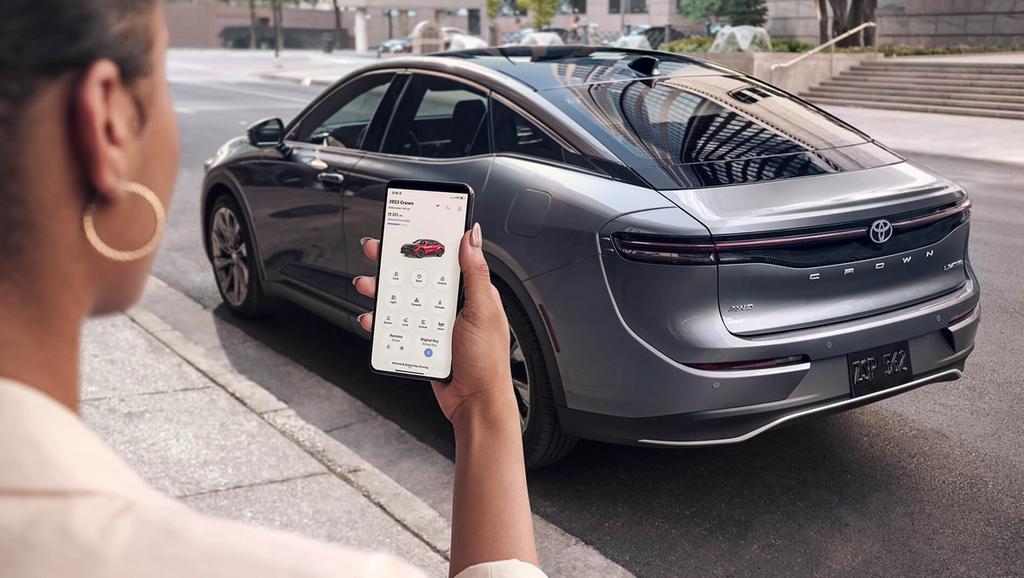 Woman using her Toyota Connected App to control her 2023 Toyota Crown while not inside the car