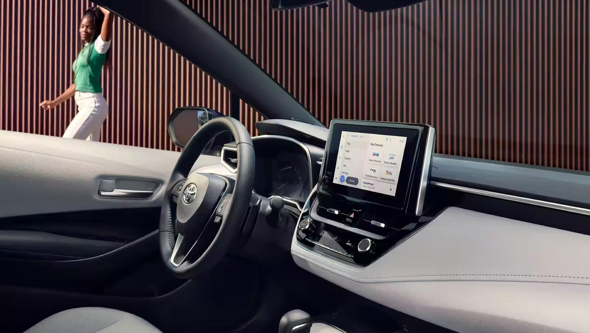 inside a Toyota Corolla Hatchback with a woman walking past outside
