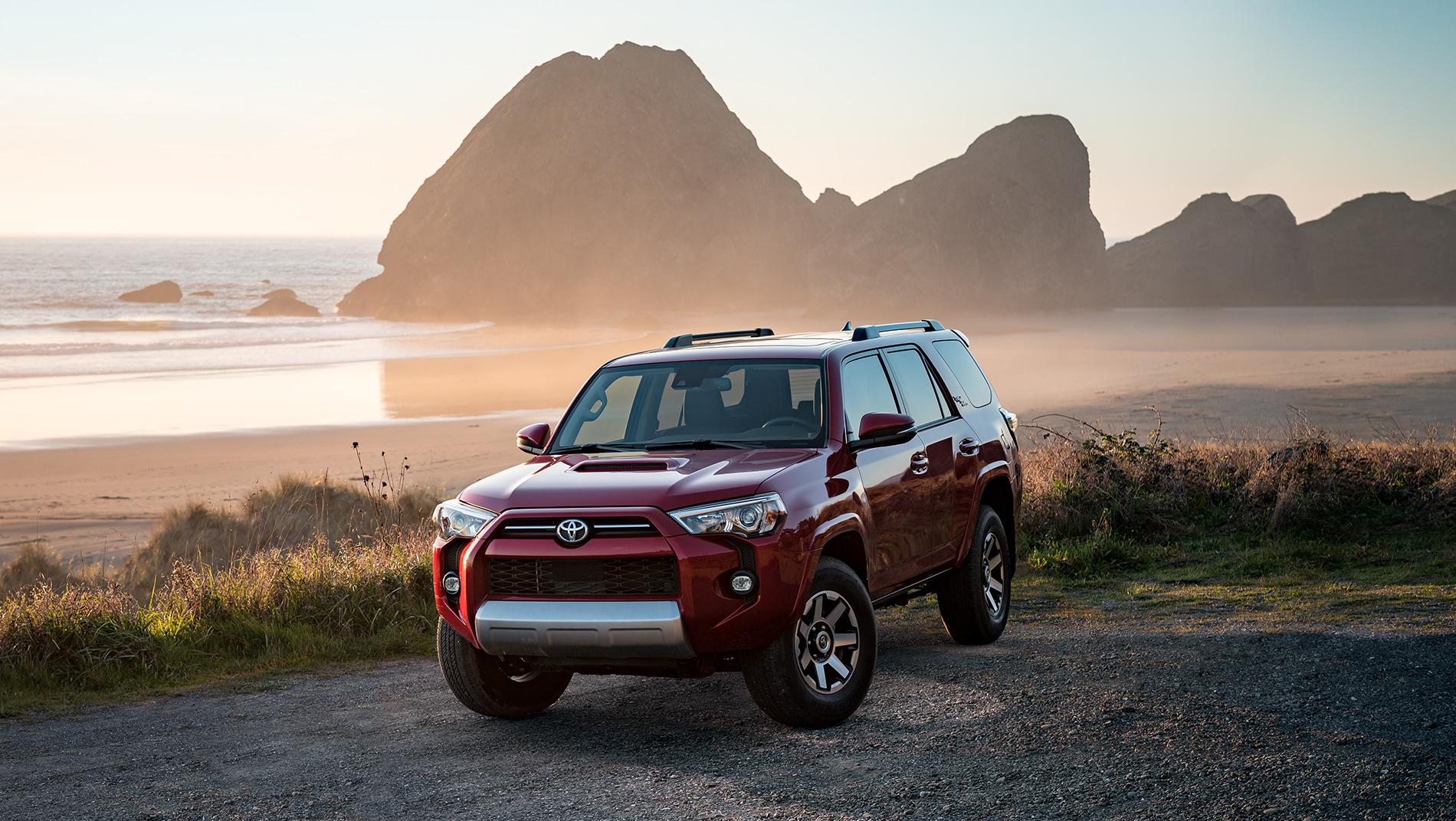 Red 2024 Toyota 4Runner parked in front of a rocky ocean coastline