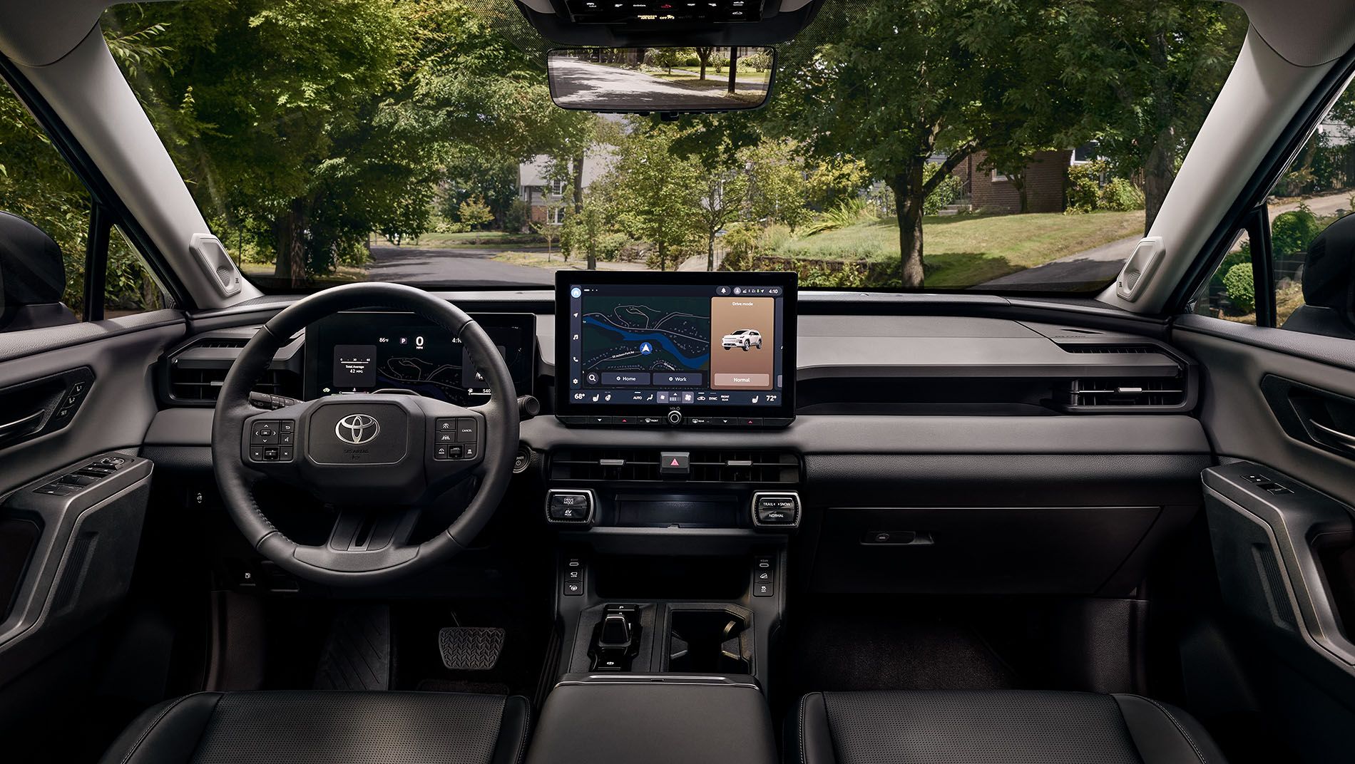 Interior view of a Toyota RAV4 Hybrid HEV featuring the rows of seats in various colors. Is also showing the steering wheel, digital dashboard, and a touchscreen navigation system.