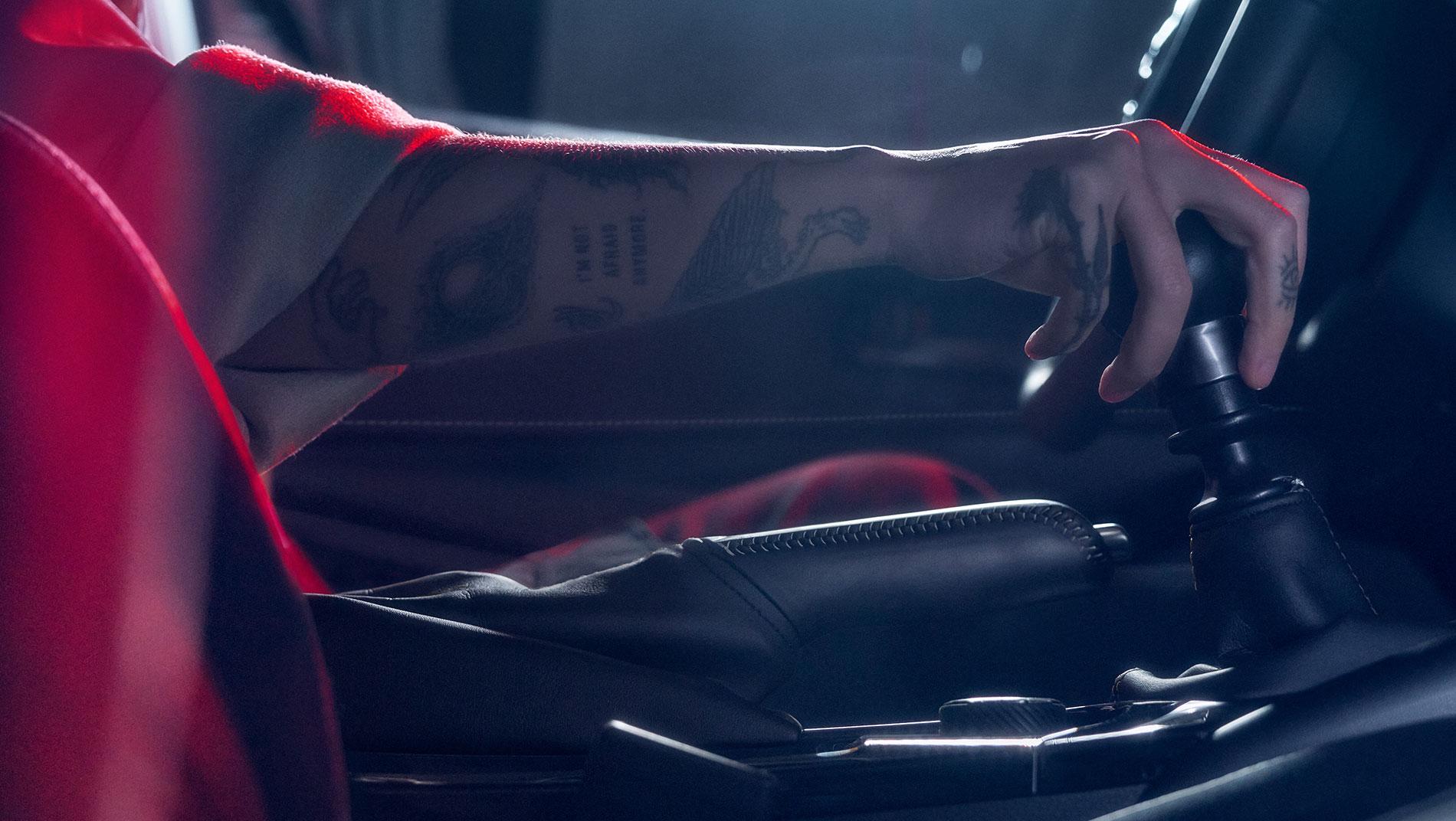 Person shifting the manual transmission of a 2024 Toyota GR Corolla with black leather interior