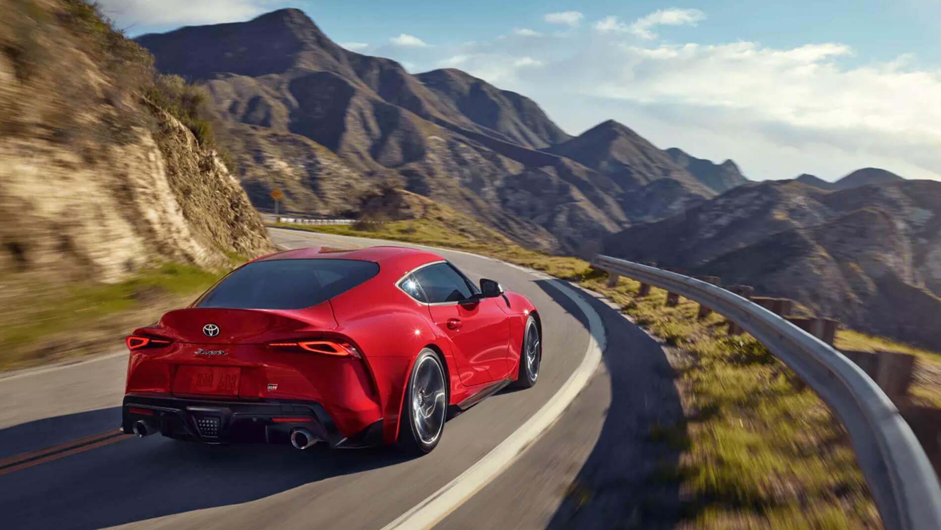 2023 Toyota Supra red driving down curvy mountain road