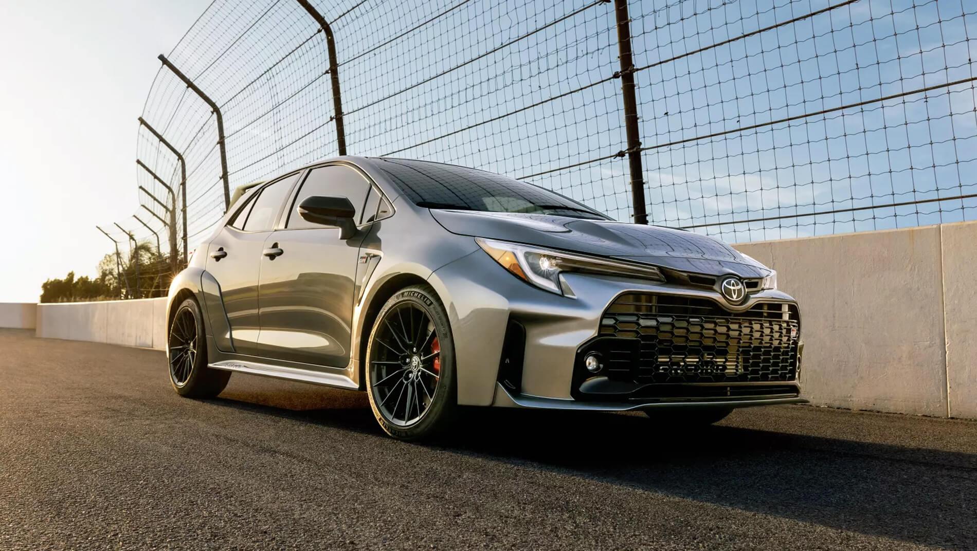 2023 Toyota GR Corolla driving along the fence on a race track