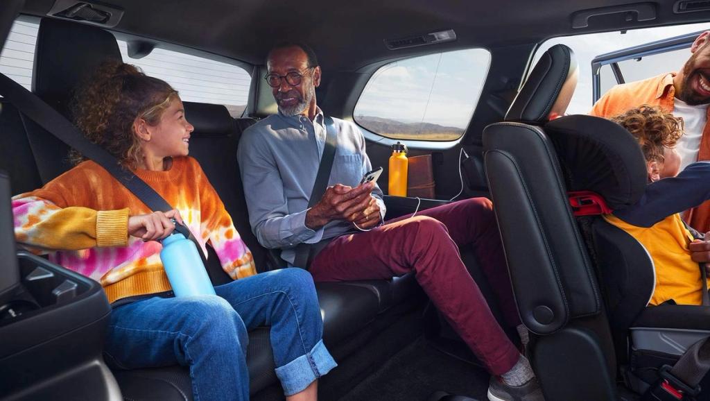 2024 Toyota Grand Highlander inside third row with adult man and teenager and second row with toddler sitting