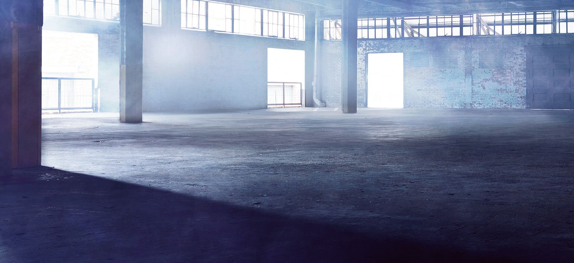 empty warehouse with light streaming in through windows