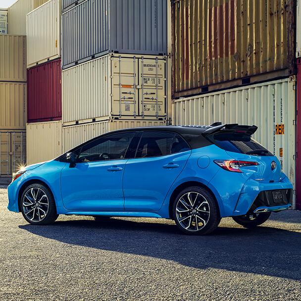 Blue Toyota Corolla Hatchback parked ina shipping yard