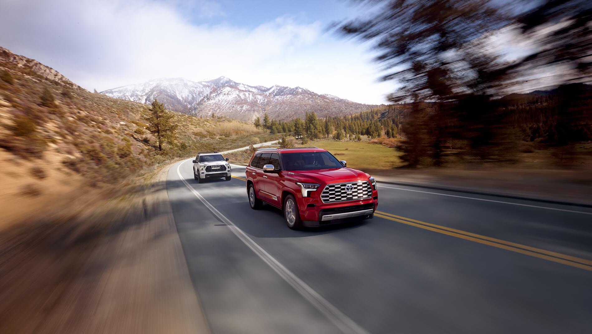 Red Toyota Sequoia driving down mountain road followed by silver Toyota