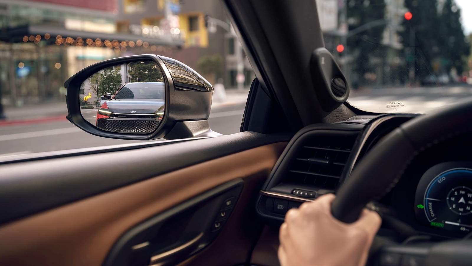 inside a Toyota Crown Signia driving down a rainy city street