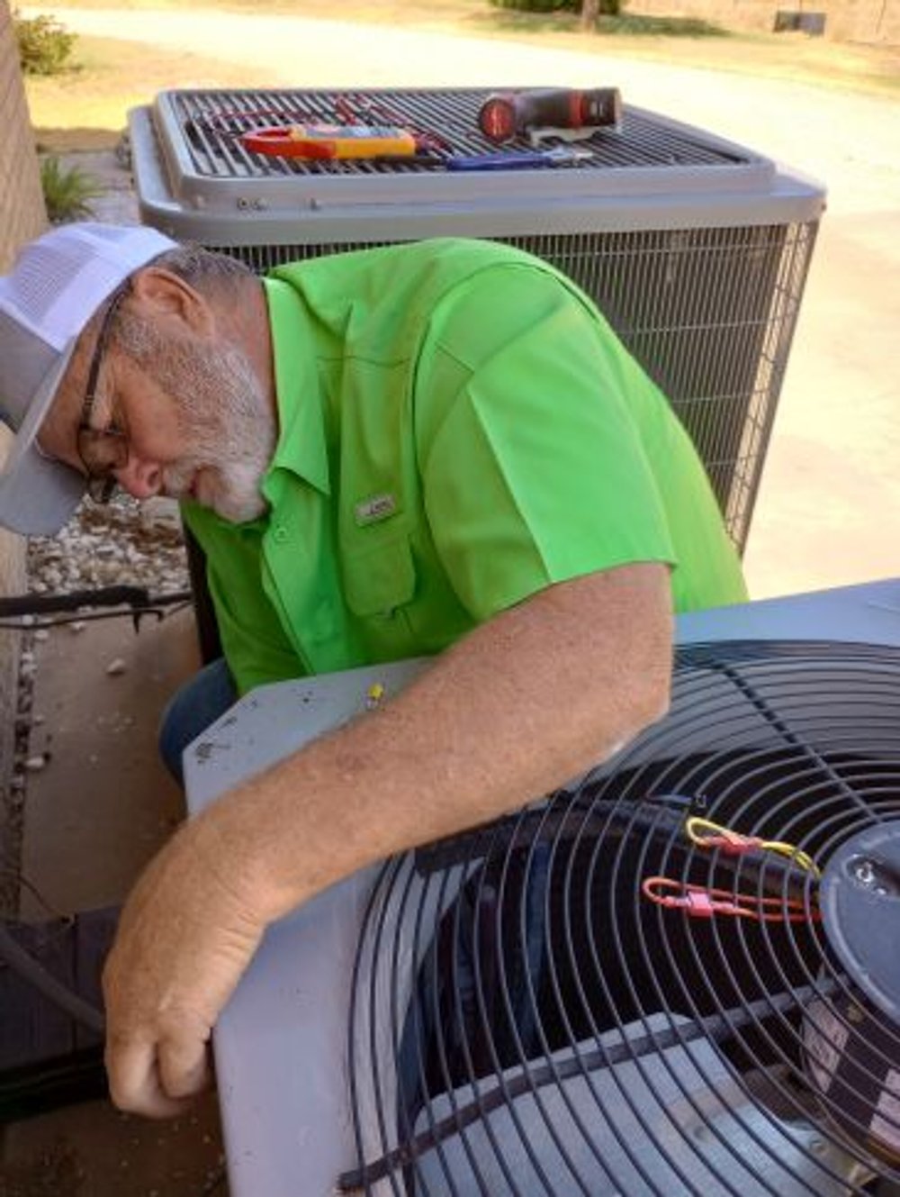 Owner, Shane Clark, works on a condenser at customer's home.