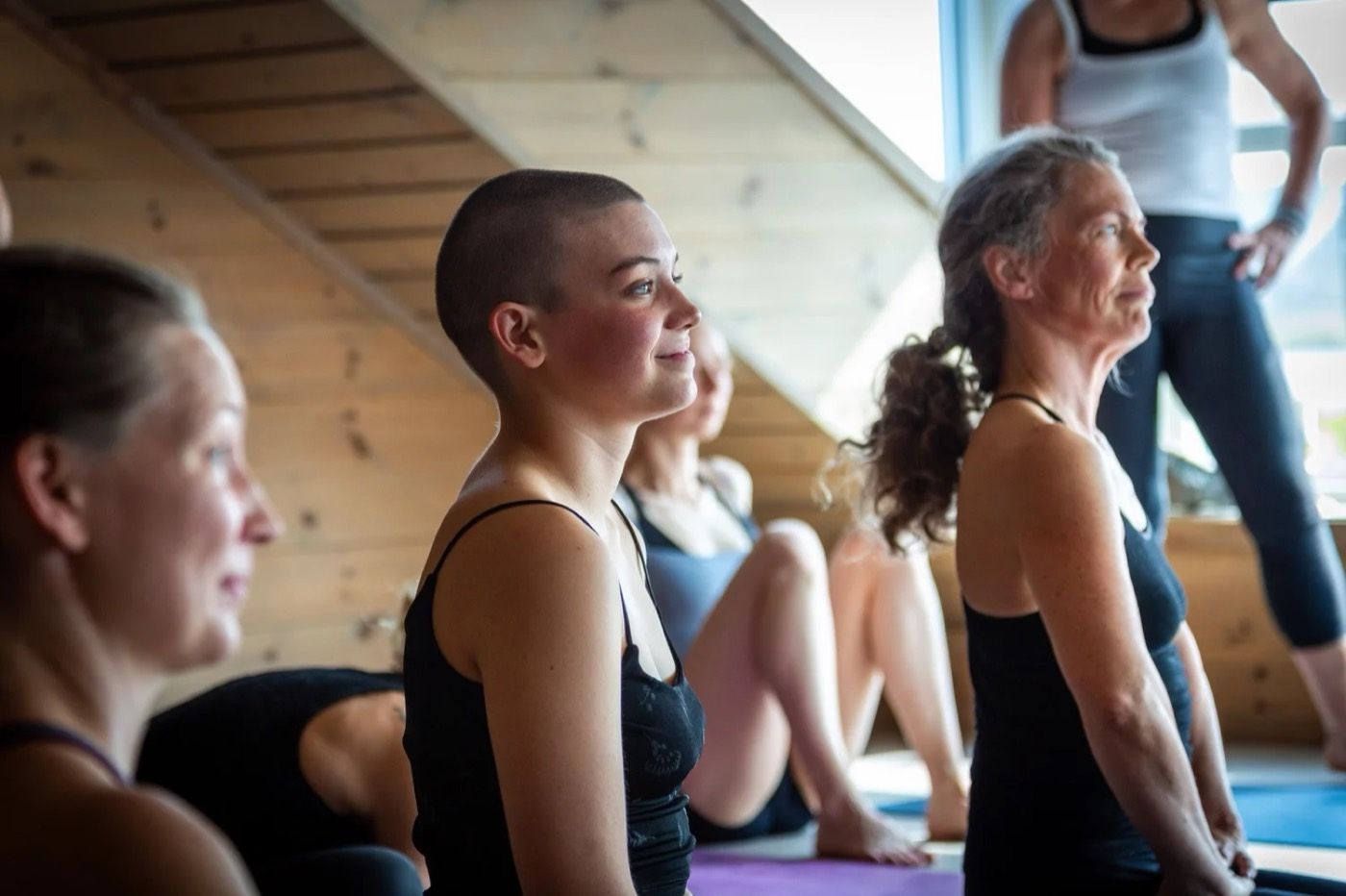 People smiling during a yoga class in a wooden shala