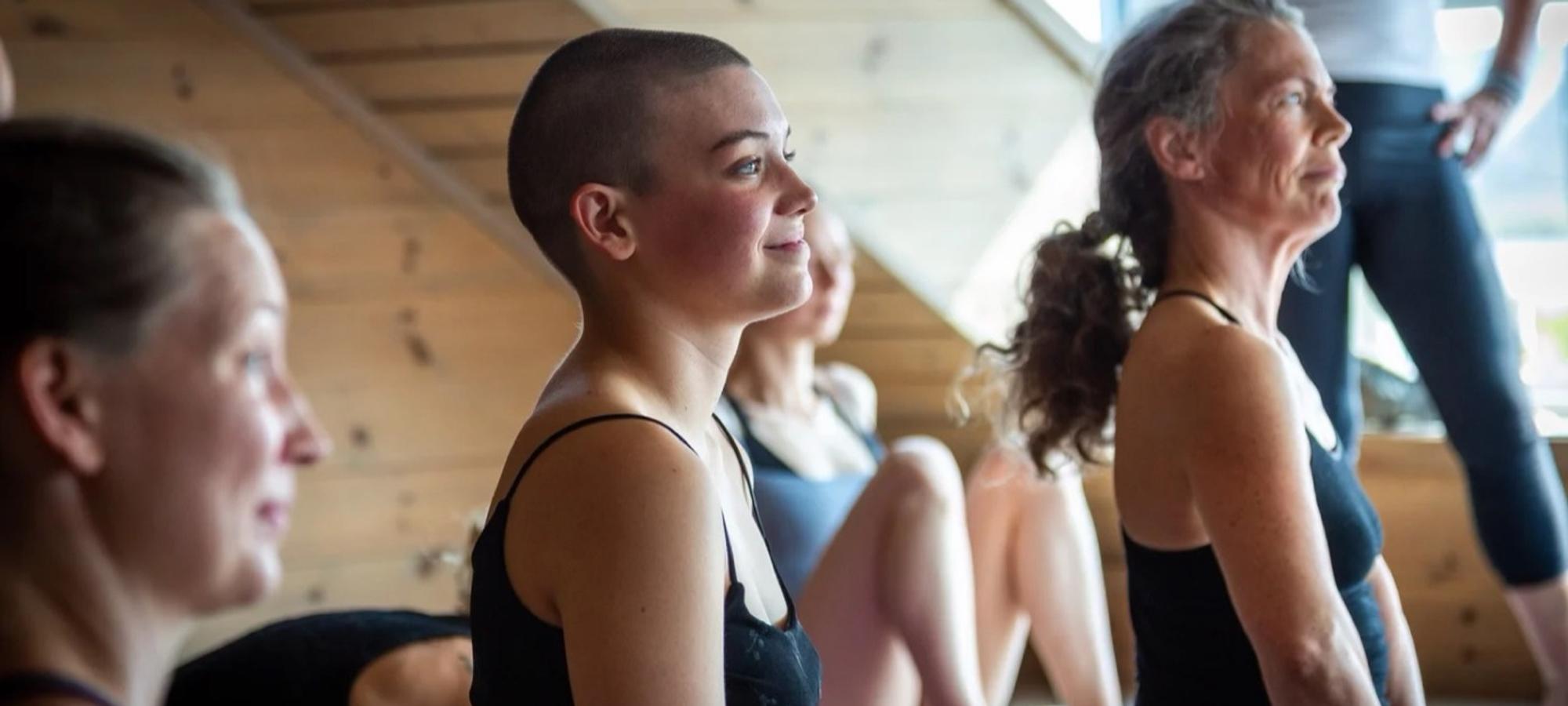 People smiling during a yoga class in a wooden shala