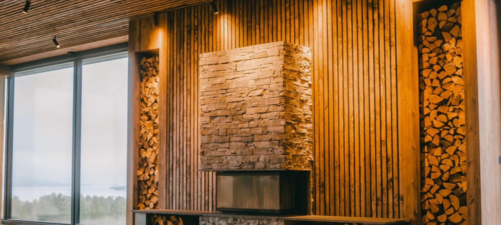 Shala Lakshmi: a tall wooden hall with a slatted ceiling and a stone fireplace