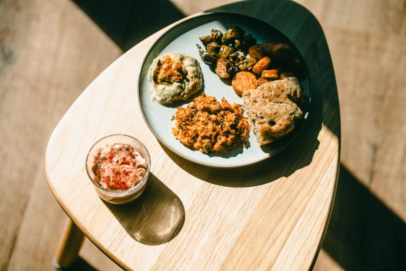 A plate of vegetarian dishes on a wooden table in the sun