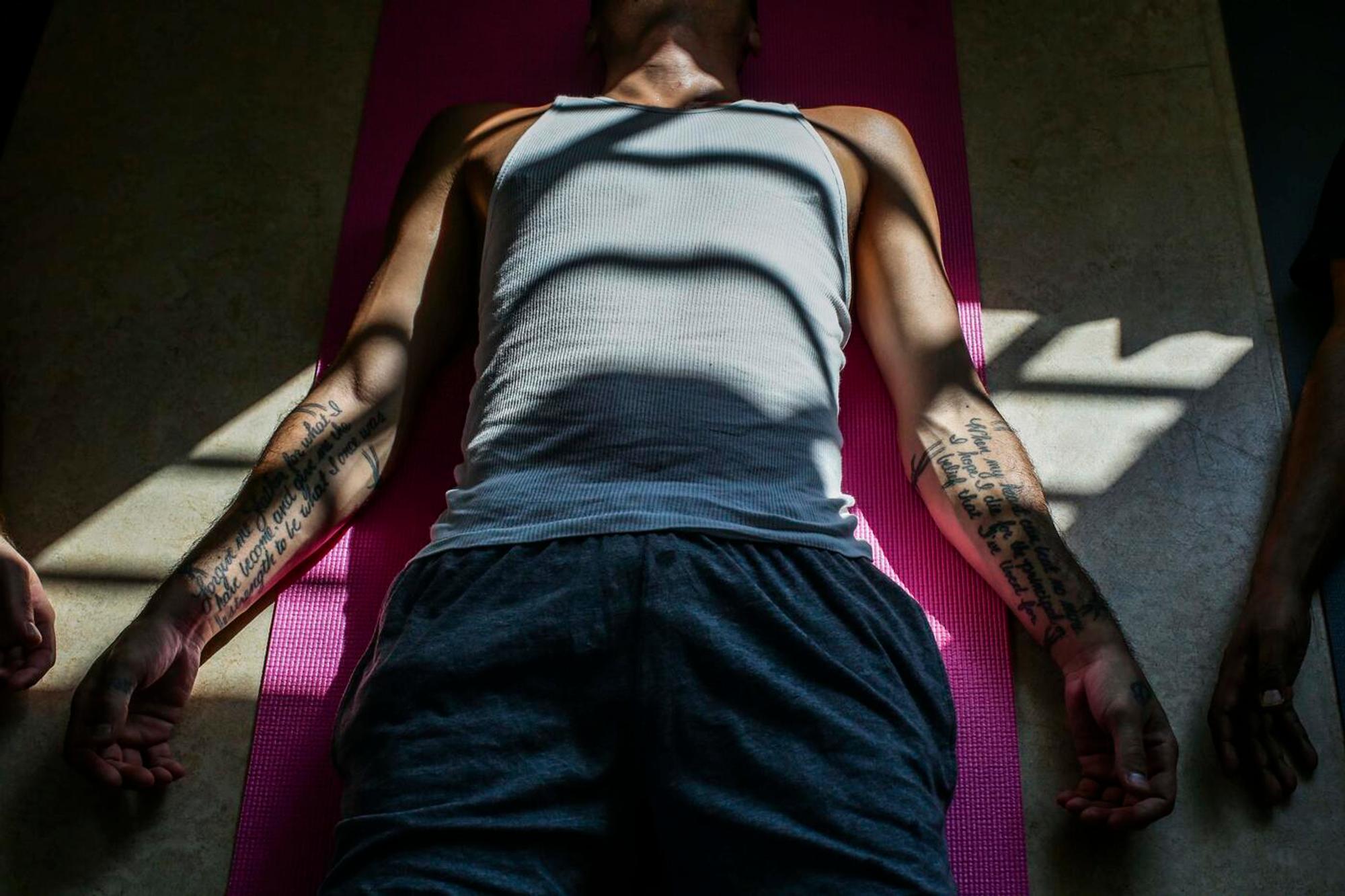 Gangster Yoga: en tatovert mann hviler på matten sin