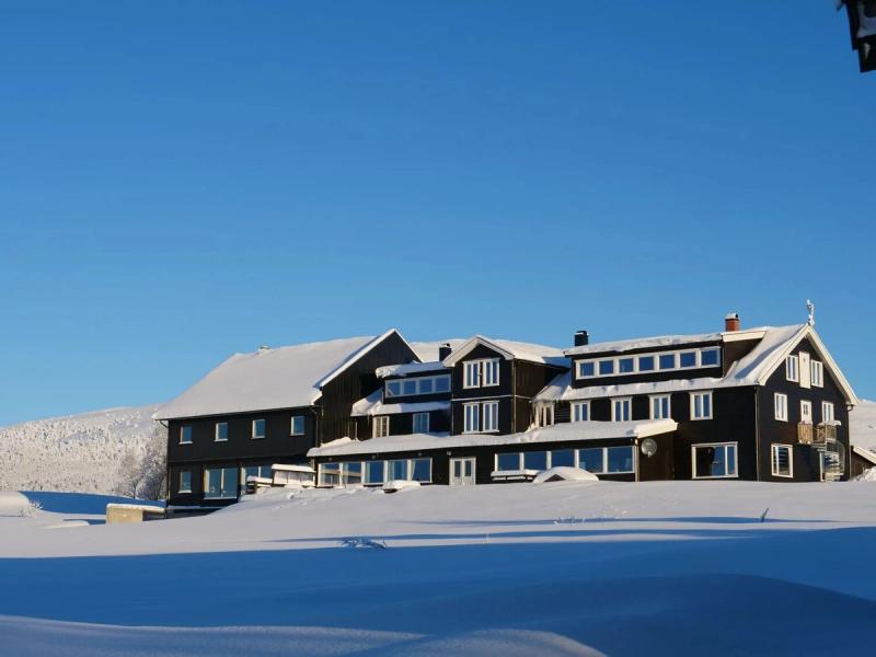 The hotel in deep snow under a blue sky