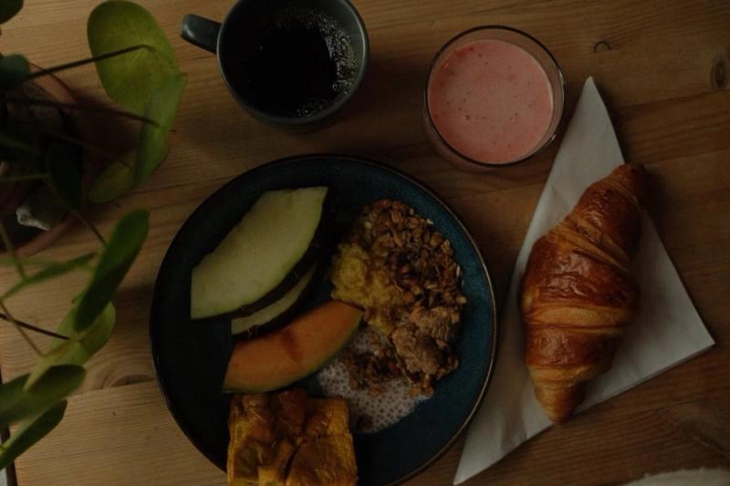 Frokosttallerken med frukt, en croissant og en smoothie