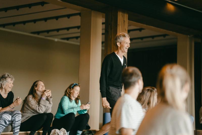 A teacher talking to a laughing group at the yoga festival