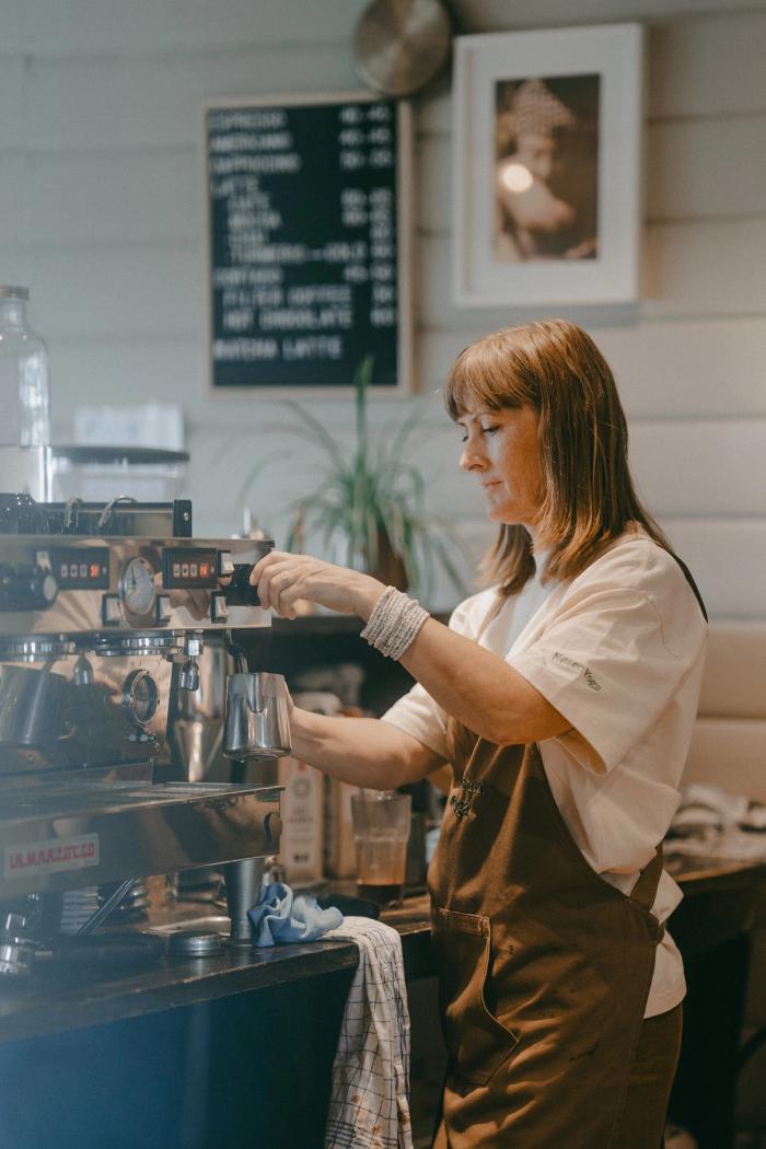 En barista lager kaffe på espressomaskinen i kafeen