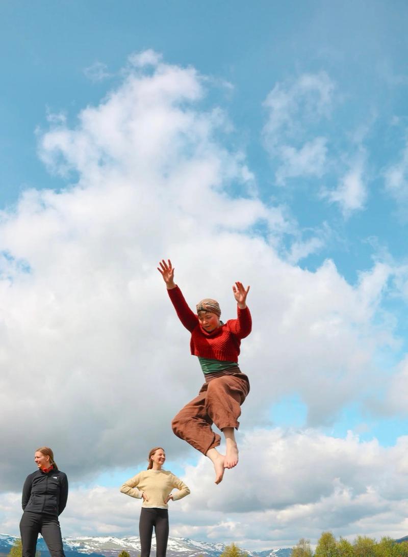 A person jumping in the air against a cloudy sky