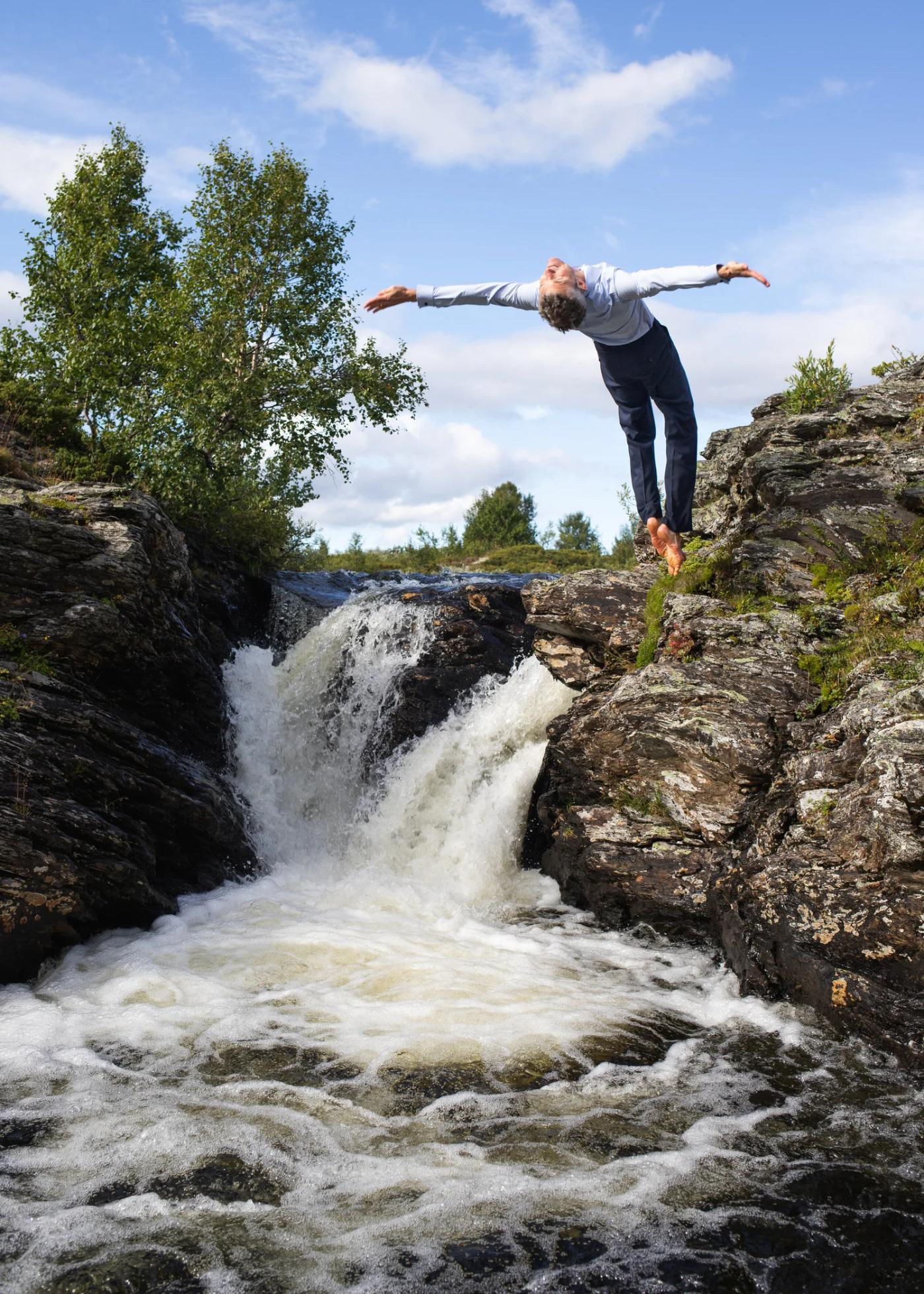 Alexander diving backwards into the lake in a suit
