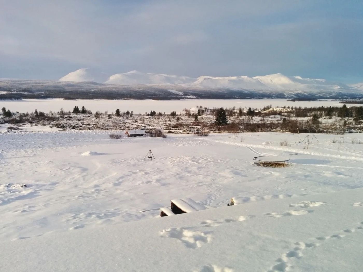 Snowy view from the dining hall across the frozen lake to Skogshorn