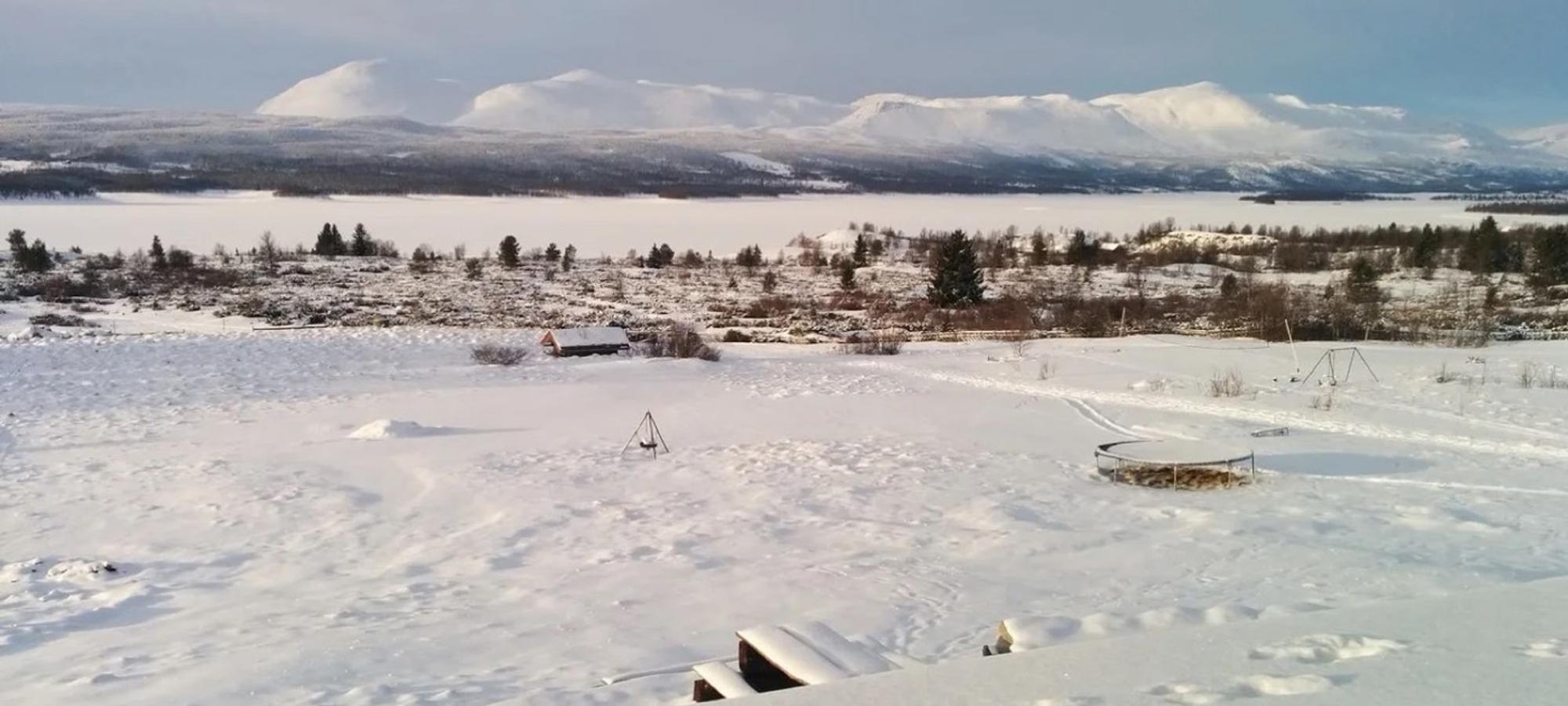 Snowy view from the dining hall across the frozen lake to Skogshorn