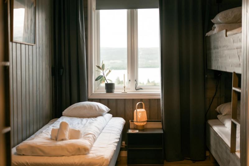 A single room with bunk beds and a window onto the lake