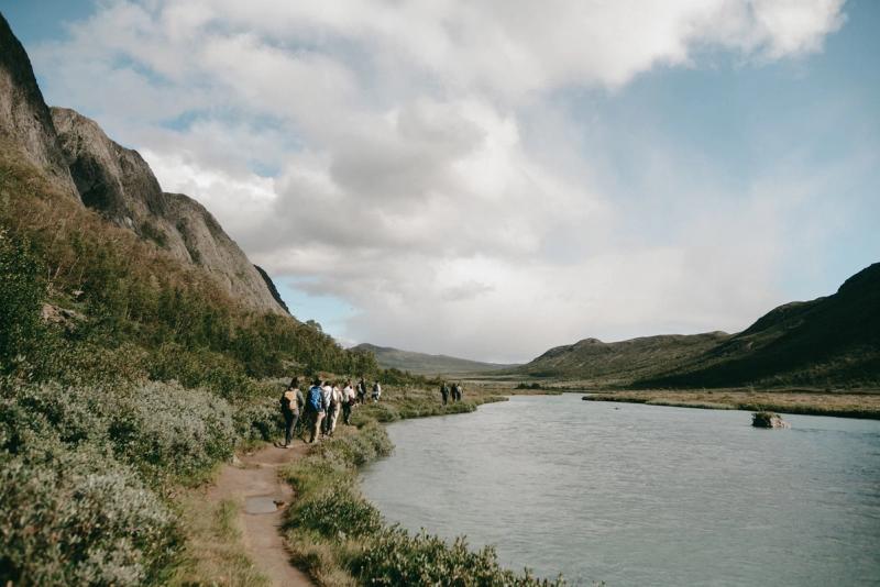 A group walking the path along the river in the valley