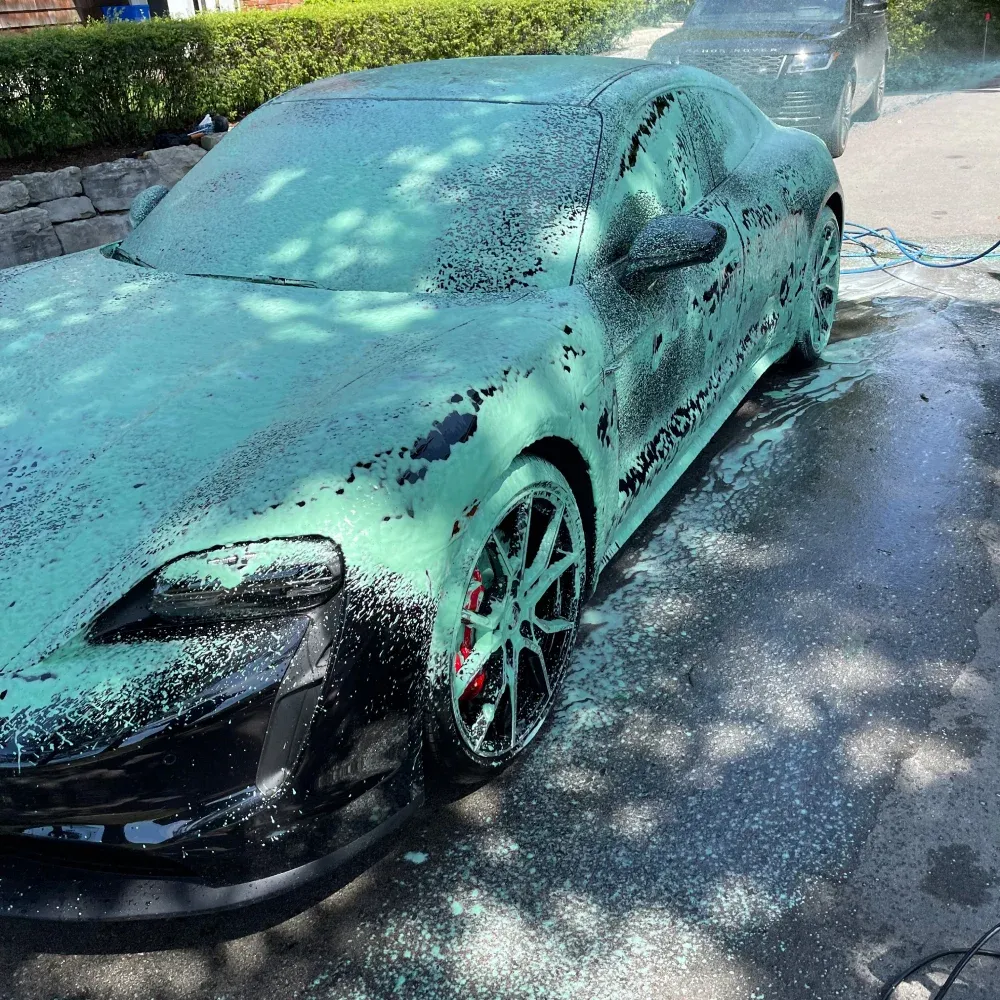 person detailing a sleek, white car, using a soft microfiber towel to polish the surface