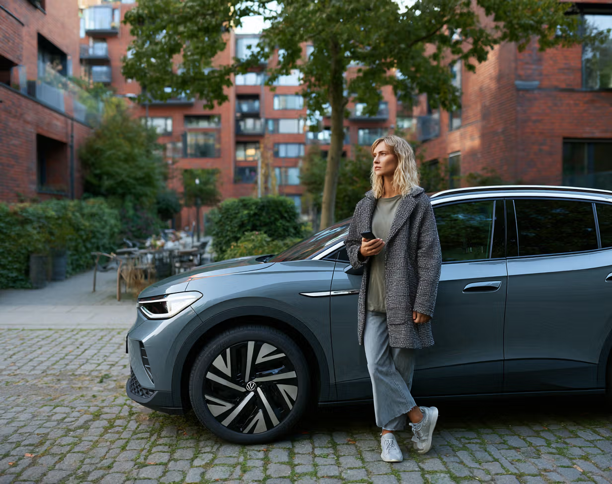 Frau vor E-Auto in der Stadt