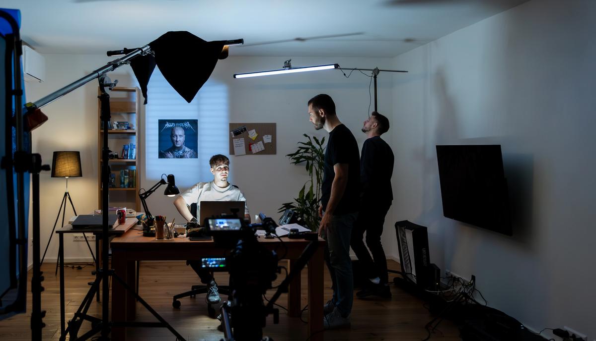 Weitwinkel des Drehorts mit Softbox, Kameraaufbau und zwei Personen im Hintergrund.