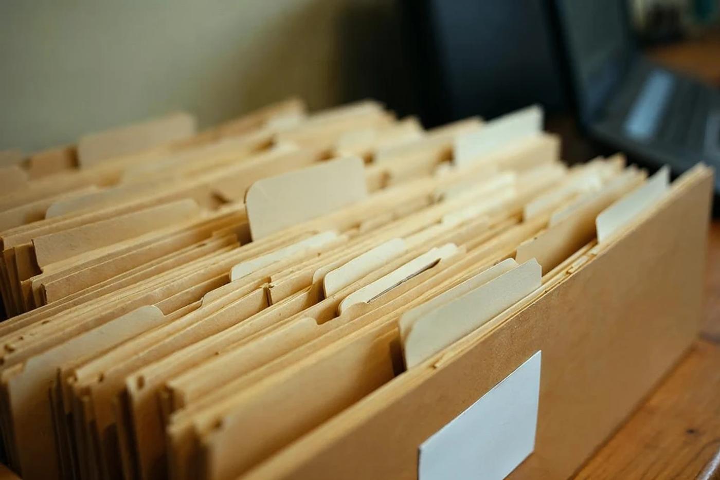 A stack of deal folders representing ongoing angel investment deal flow