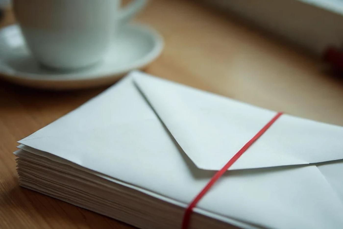 A bundled stack of envelopes representing physician student loan paperwork and repayment decisions