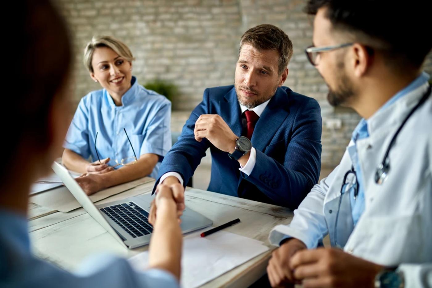 business advisor and healthcare professional shaking hands representing a clinical advisory partnership