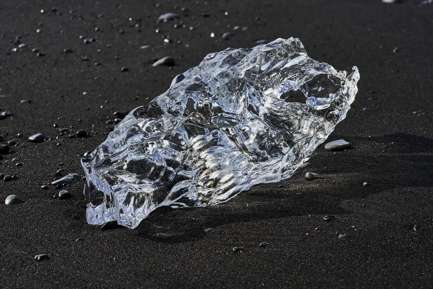 Klare Eisstücke auf schwarzem Sand