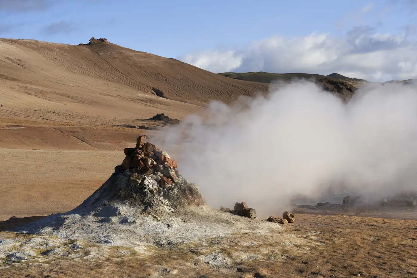 Dampf steigt über einem geothermalen Hang