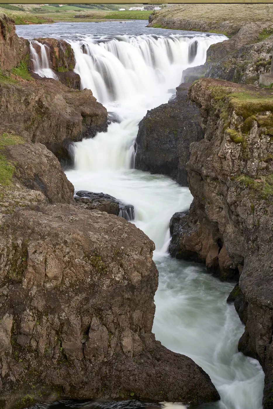 Ein Wasserfall an einem grünen Hang
