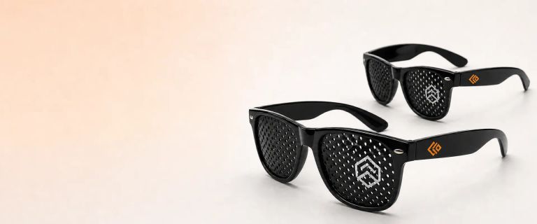 Black custom pinhole sunglasses with branded logos on the lenses and temples