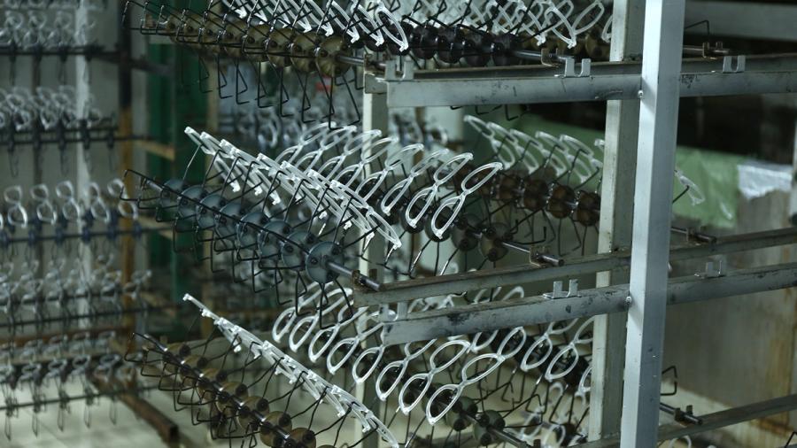 Sunglasses frames arranged on production racks in an eyewear factory