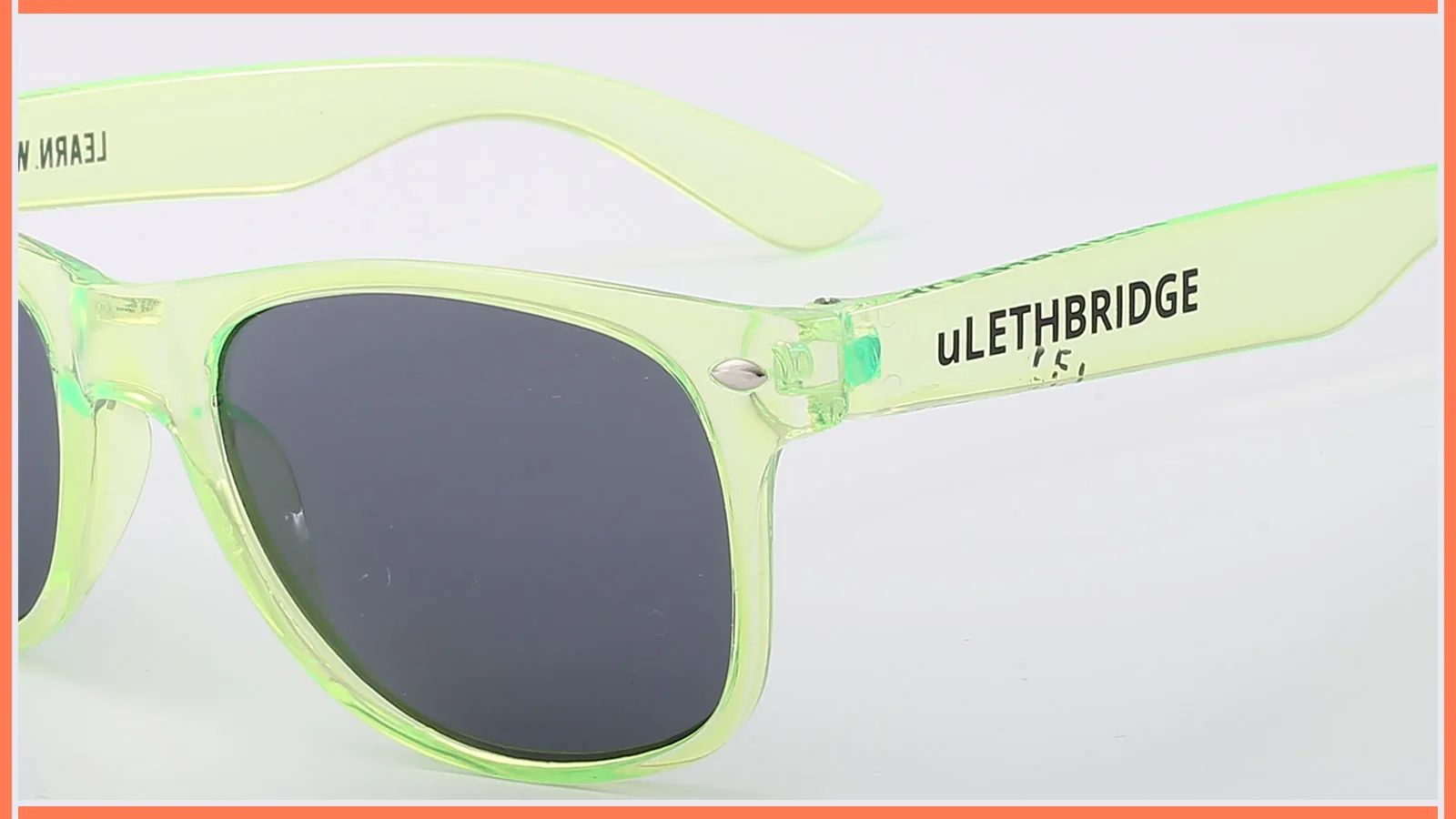 Misprinted black logo artwork on a translucent green sunglasses temple