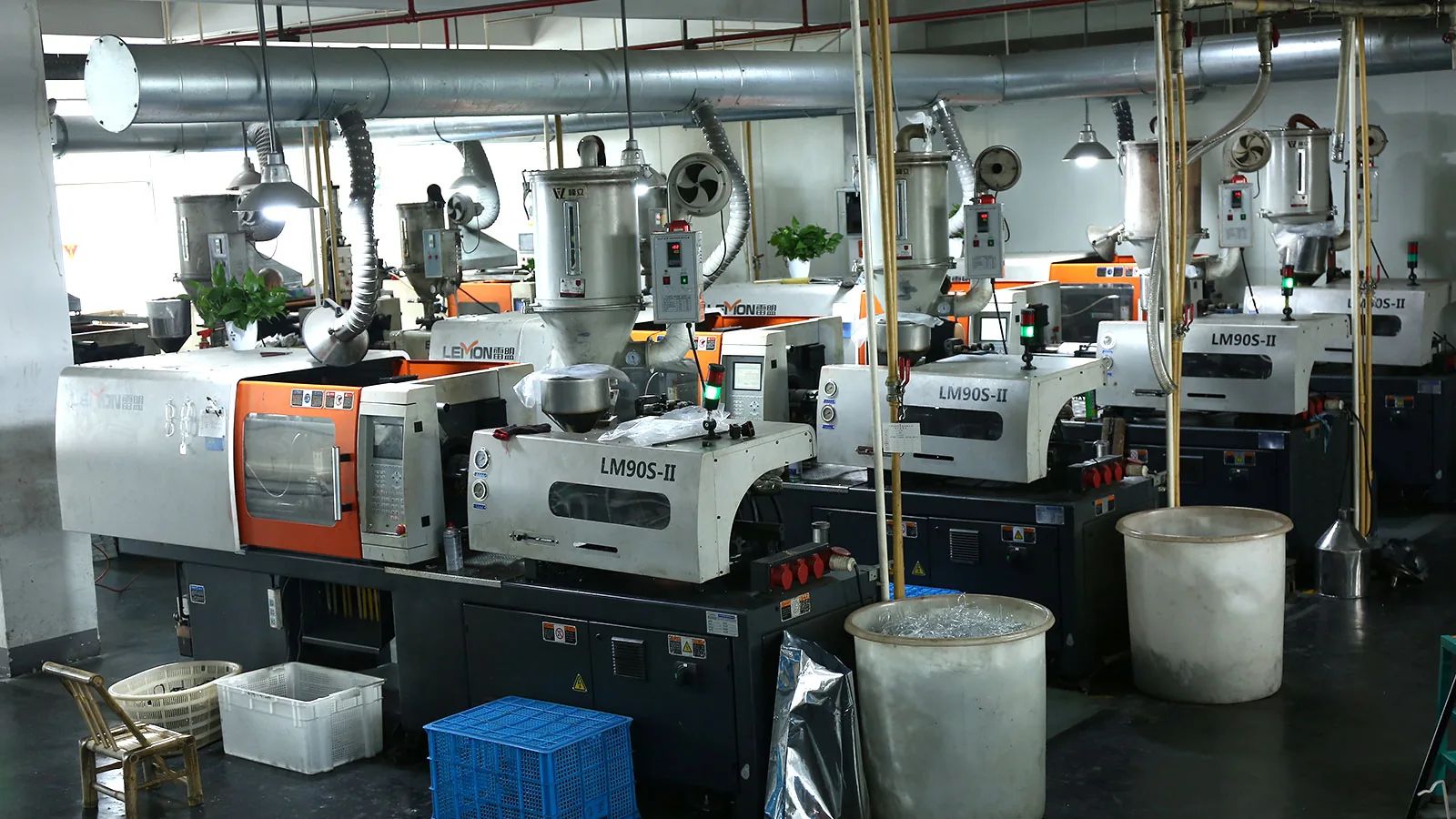 Injection molding machines operating inside a sunglasses factory workshop
