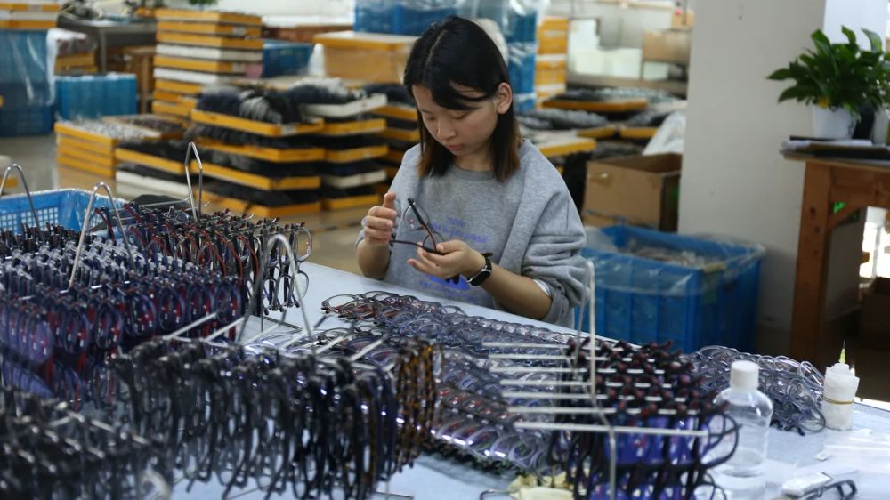 Worker inspecting sunglasses frames in a manufacturing facility