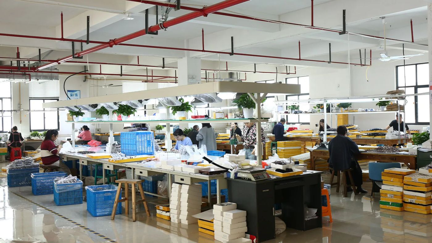 DOMI Eyewear production floor with workers assembling and checking eyewear