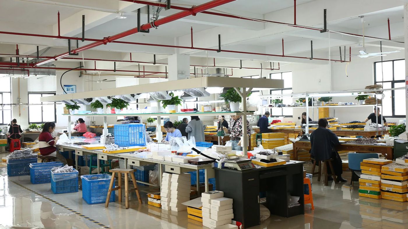 DOMI Eyewear production floor with workers assembling and checking eyewear