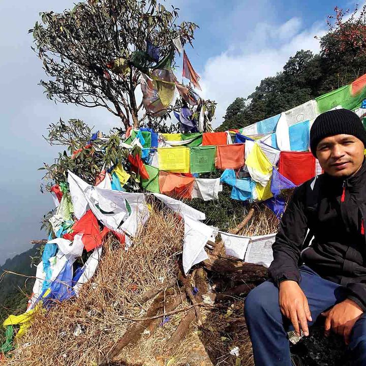Govinda Shahi in a mountain setting with Nepalese prayer flags