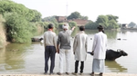 a picture of farmers looking at a checkdam filled with water