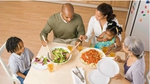 "Mother & father serving two children dinner at table