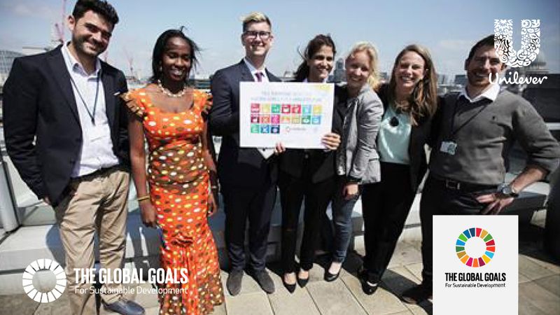 A group of people posing for the picture holding a board with UN's SDGs